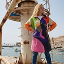 The model poses in a colorful rain cape 
