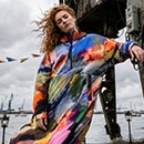 The model poses in a colorful rain cape 
