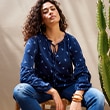 The model wears a blue shirt with patterns