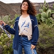 The model wears a blue cardigan