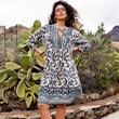 The model wears a dress with patterns