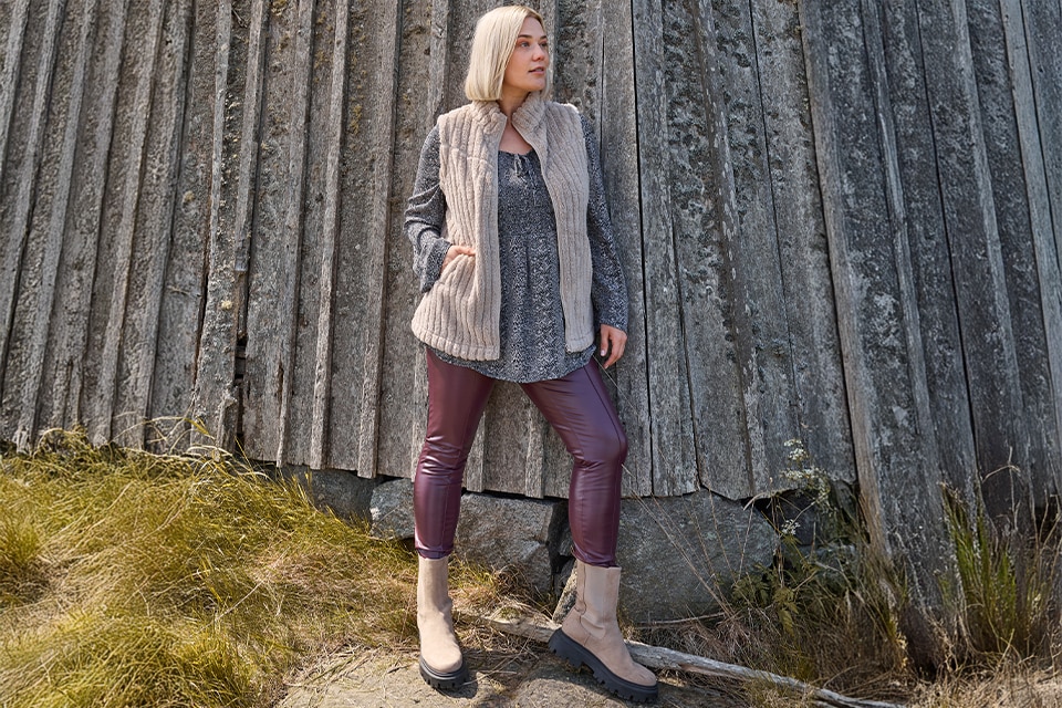 The model is wearing a brown jacket