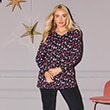 The model is wearing a long-sleeved shirt with a Christmas pattern.