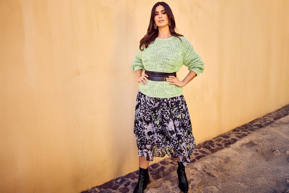 The model is wearing a green jumper