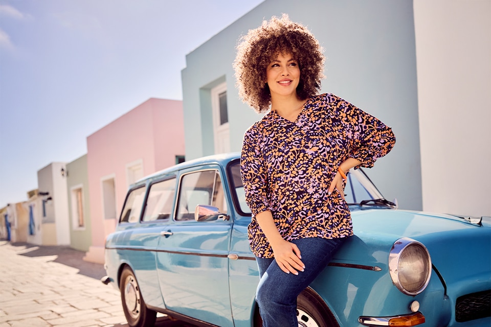 The model is wearing a orange shirt and jeans.