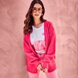 The model is wearing a pink cardigan.