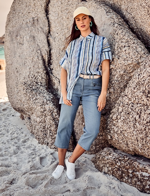 The model is wearing a blue-striped blouse and jeans.