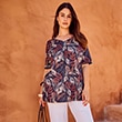 The model is wearing a blue shirt with colorful leaves