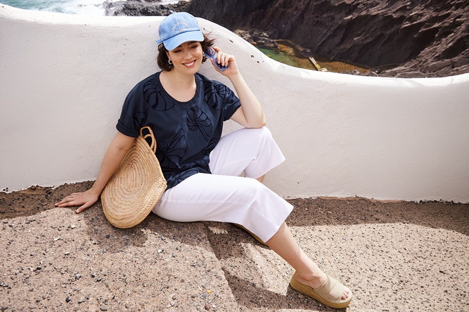The model is wearing a navy shirt wirth a white jeans.