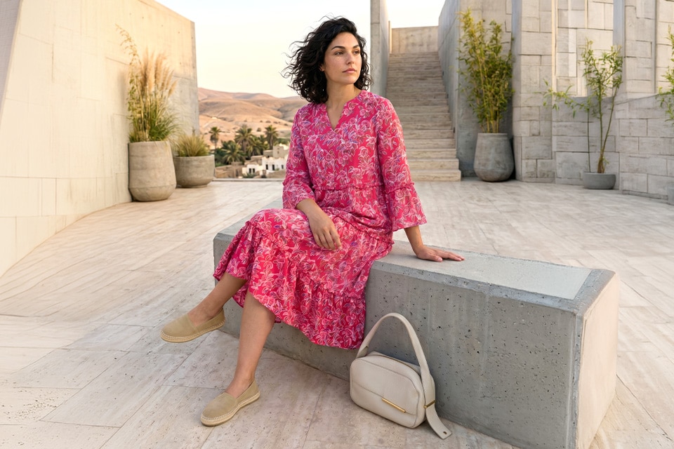 The model is wearing a long, pink dress.