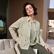 The model is wearing a green striped blouse.