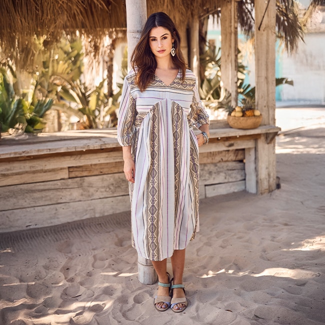 The model poses in a blouse with a black and white pattern
