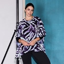 The model wears a patterned blouse in purple, black and white