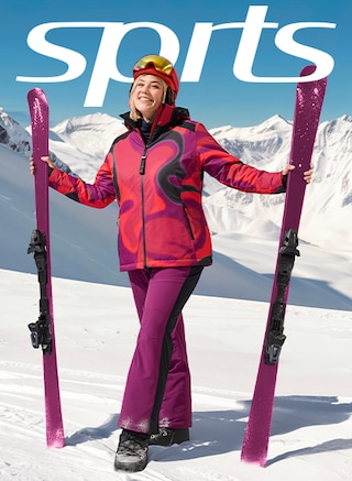 The model poses in a ski jacket and matching ski pants