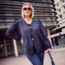 the model wears a blue blouse with pattern		

