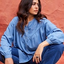 the model wears a blue blouse
