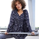 the model wears a black blouse with pattern