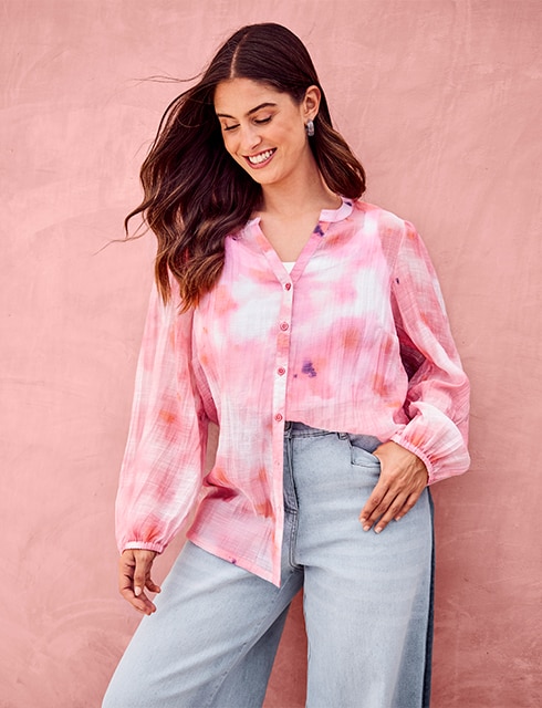 the model wears a colorful blouse and a jeans