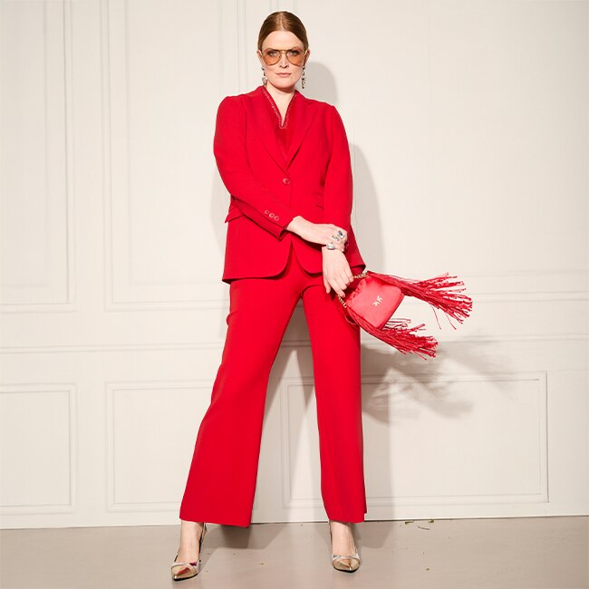 The model wears a red blazer
