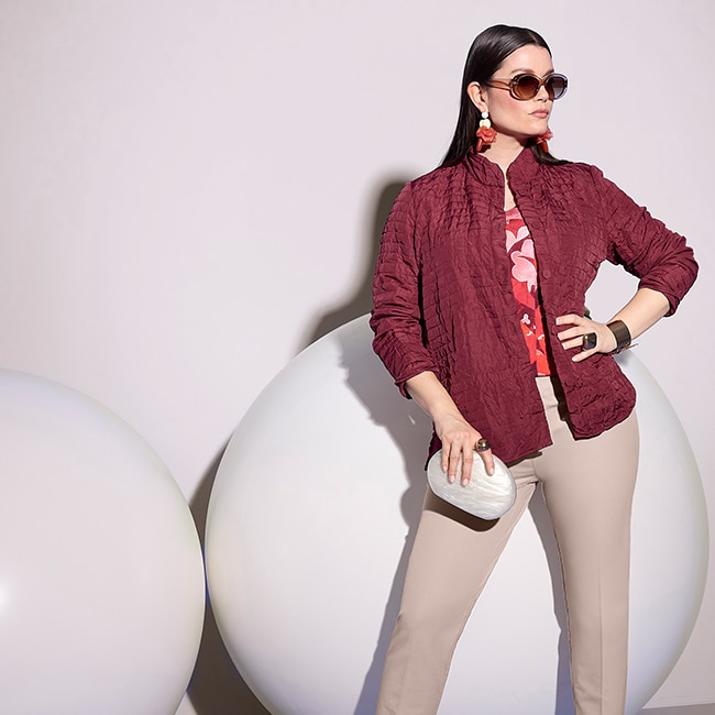 the model is wearing a dark red jacket and beige pants.