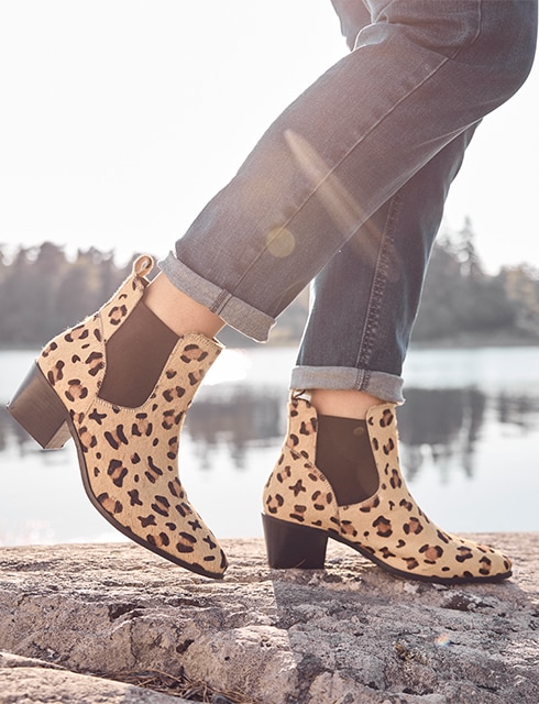 The ankle boots in the leo pattern were photographed in front of a lake