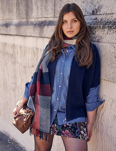 The model is wearing a colorful blouse with a red pants.
                    