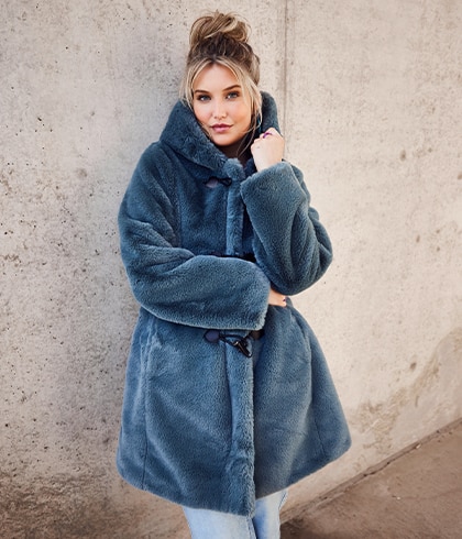 The model poses in a blue teddy coat