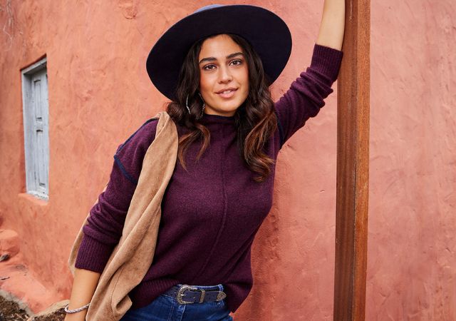A women who is sitting infront of palm trees