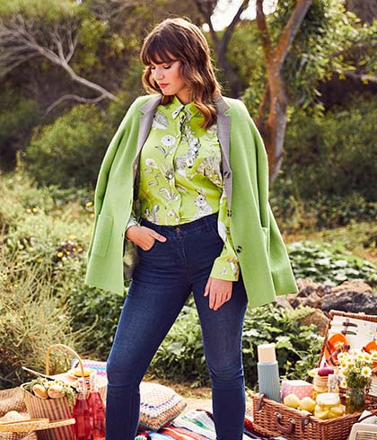 Model with green Jacket stands on a picnic blanket
