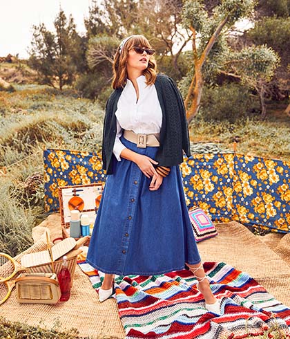 Model with jeans-skirt stands on a picnic blanket
