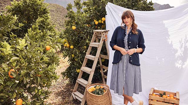 The model wears a traditional-dress while posing in a garden