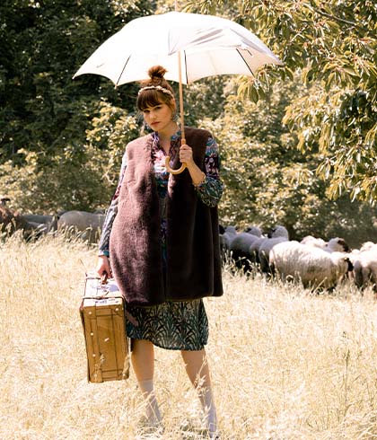 The model poses in a fur waistcoat with an umbrella 