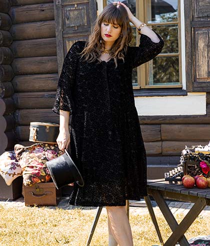 The model poses in a black velvet dress 