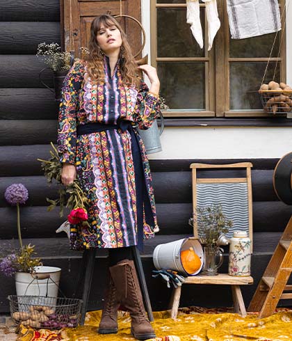 The model poses in a rural setup with flowers in her hand 