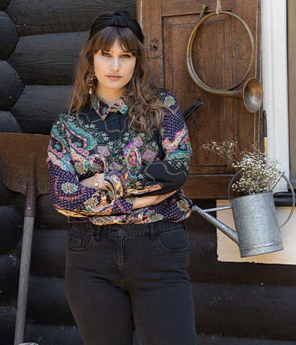 The model poses in a colourful patterned blouse 