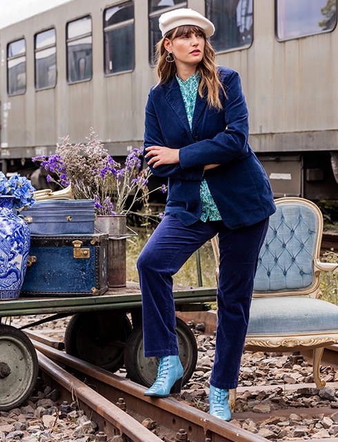 The model poses in a corduroy suit and corduroy trousers at a paralyzed freight station