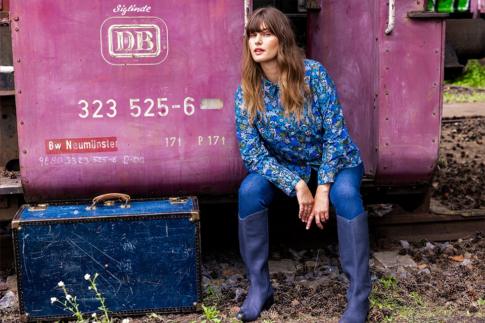 The model is wearing a blue and green patterned corduroy blouse