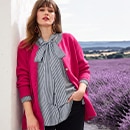 The model is wearing a white and black blouse