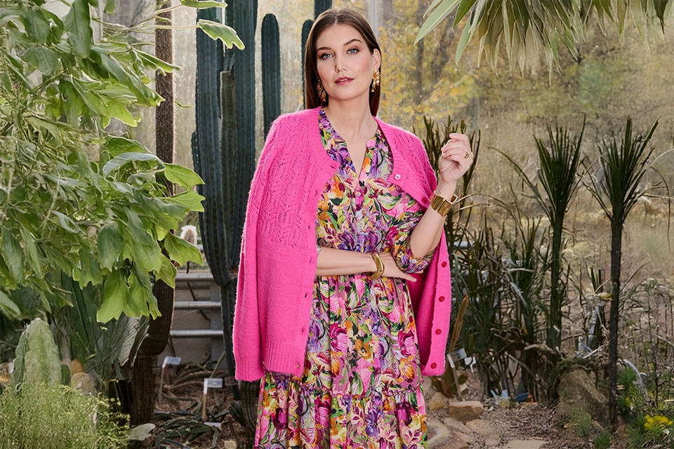 The model wears a pink cardigan 