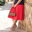 The model is wearing a red skirt