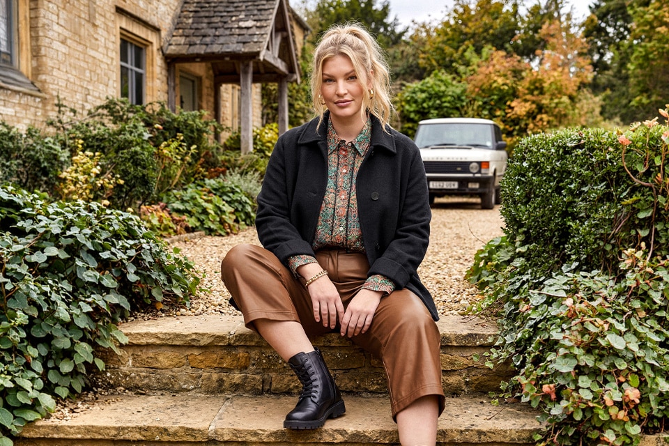 The model is wearing a leather trousers and printed shirt.