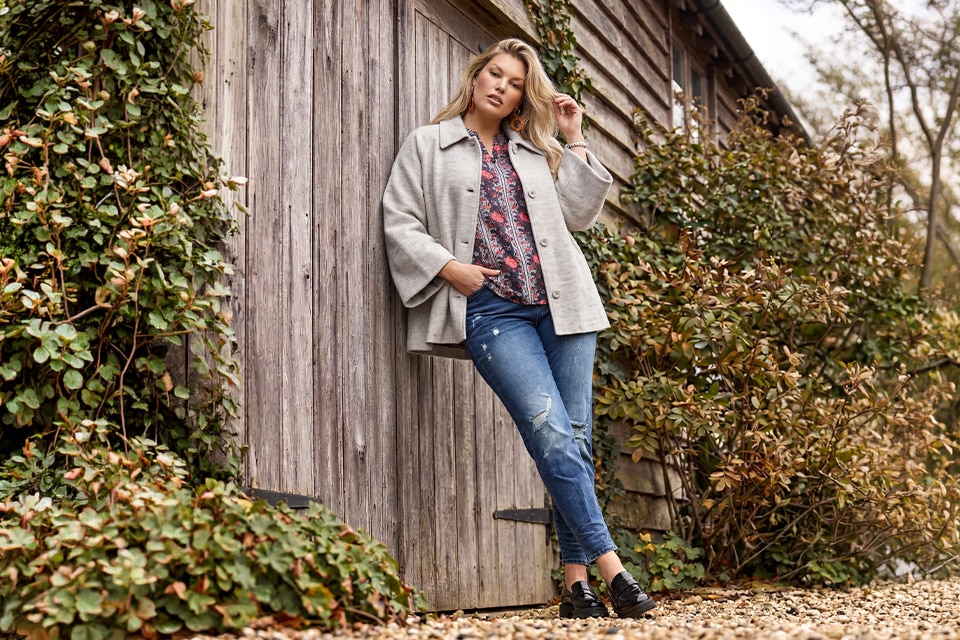 The model wears a Grey jacket a jeans and a shirt.