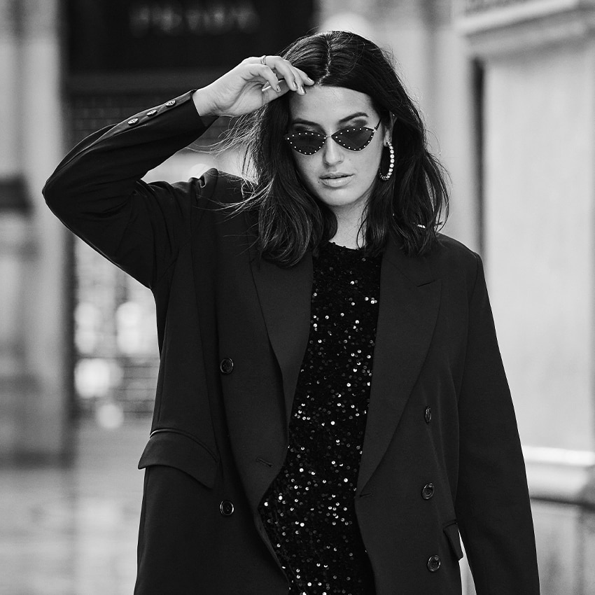 The model is posing with her hand in her hair