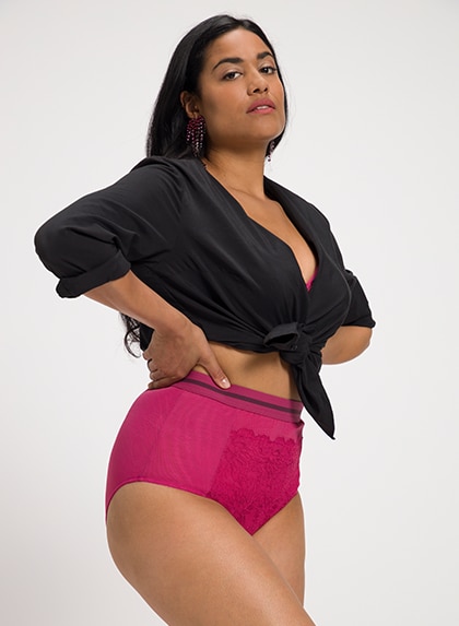 Brand Woman in the studio wears pink panties and a black knotted shirt 