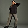 Woman posing in patterned trousers and a black sweater