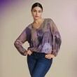Woman poses in purple blouse and blue jeans