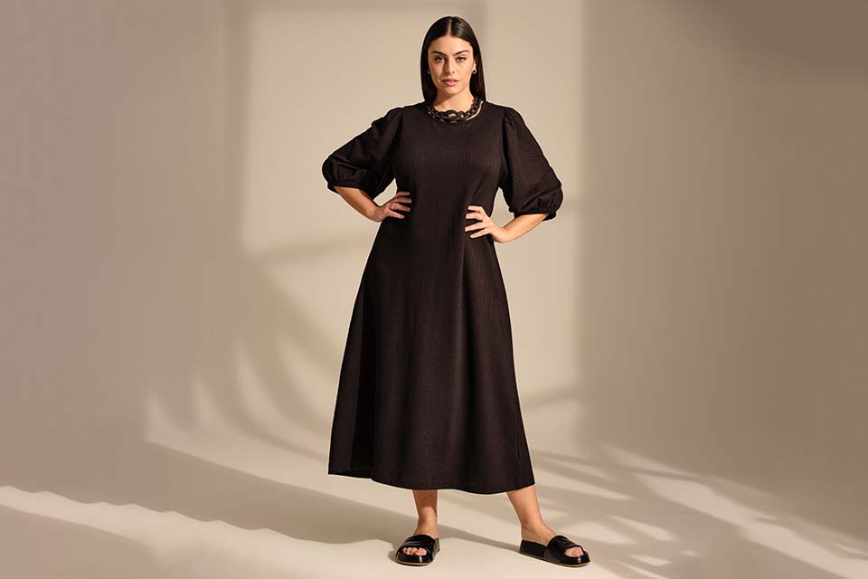 Ein Model trägt ein langärmliges schwarzes Kleid