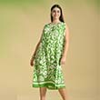 ein Model posiert vor einer grünen Wand mit grünem Kleid
