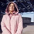 The model wears a pink quilted jacket  