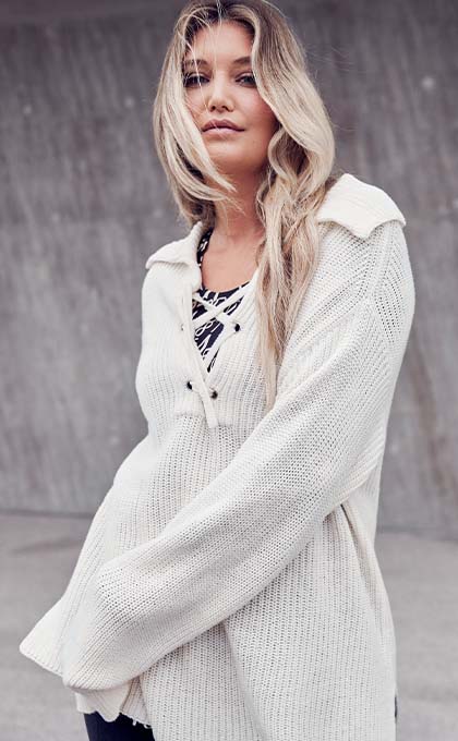 The model poses in a blue skirt and jumper